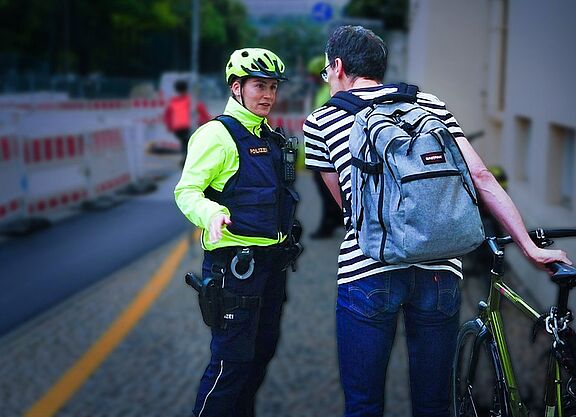 Fahrradstreife Polizistin spricht mit Radfahrer