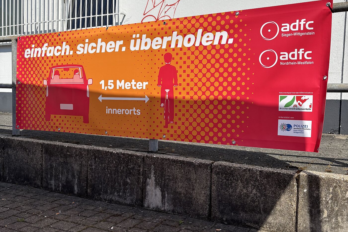 Ein Banner weist auf den gesetzlich vorgeschriebenen Überholabstand von 1,5 Metern innerorts hin.